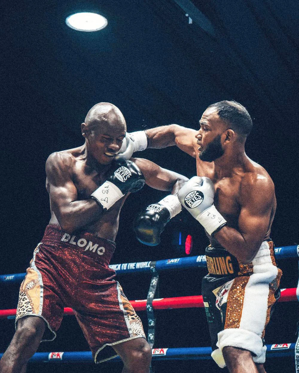Wasim Chellan lands a right hand against Prince Dlomo in the boxing ring.